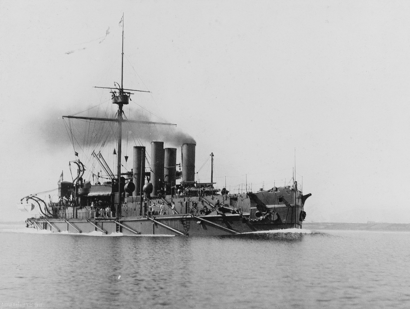 Low starboard bow view of German battleship Baden steaming in a calm sea sometime between 1892 and 1896
